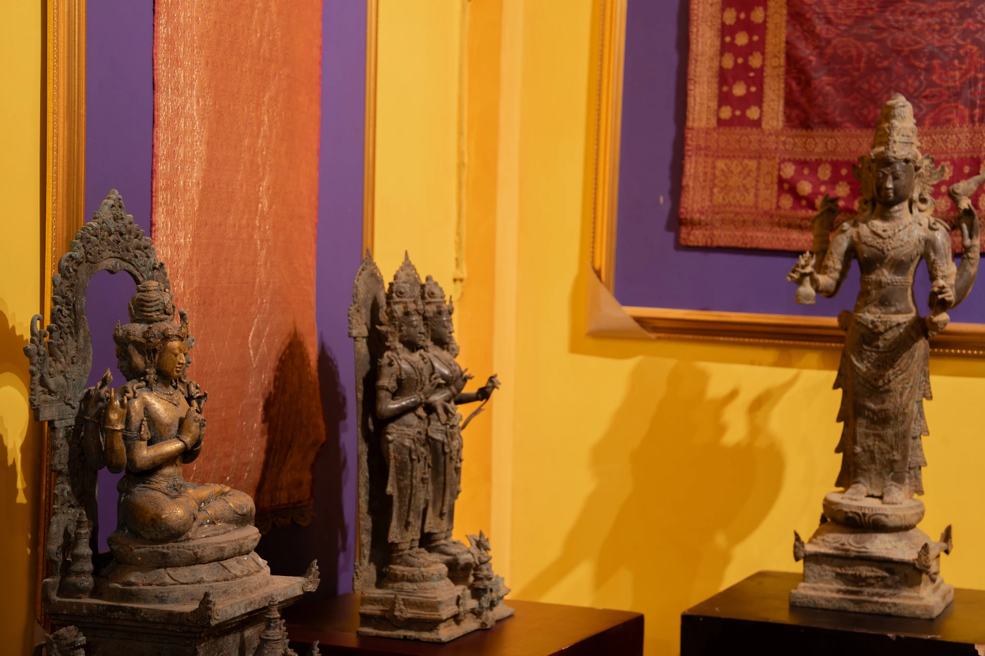 Close-up of ornate bronze Hindu-Buddhist deity statues at Museum Peter Bloch Collection.