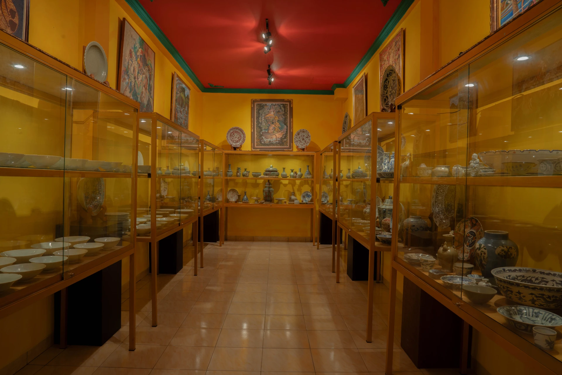 Curated corner of the Extra Room featuring a red lacquered cabinet and antique Chinese sculptures, Museum Peter Bloch Collection.