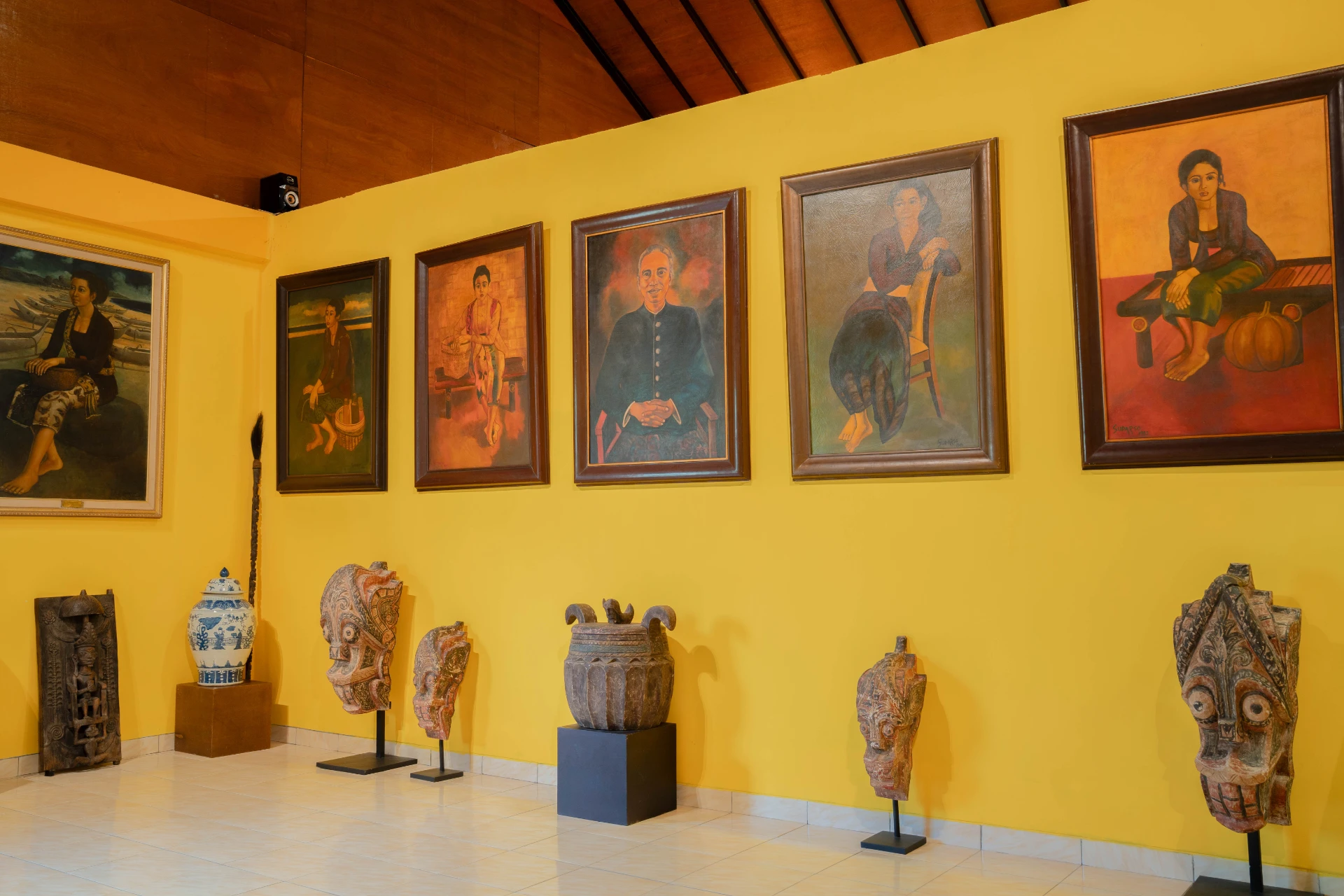 Curated selection of antique ceramic jars and small figurines on a gallery table, Adam Malik Room.