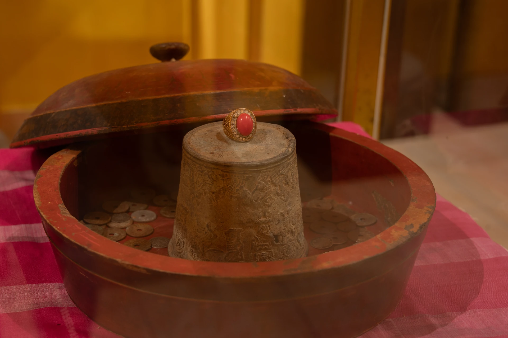 Antique gold ring with a large red gemstone and ancient coins on display, Museum Peter Bloch Collection jewelry.