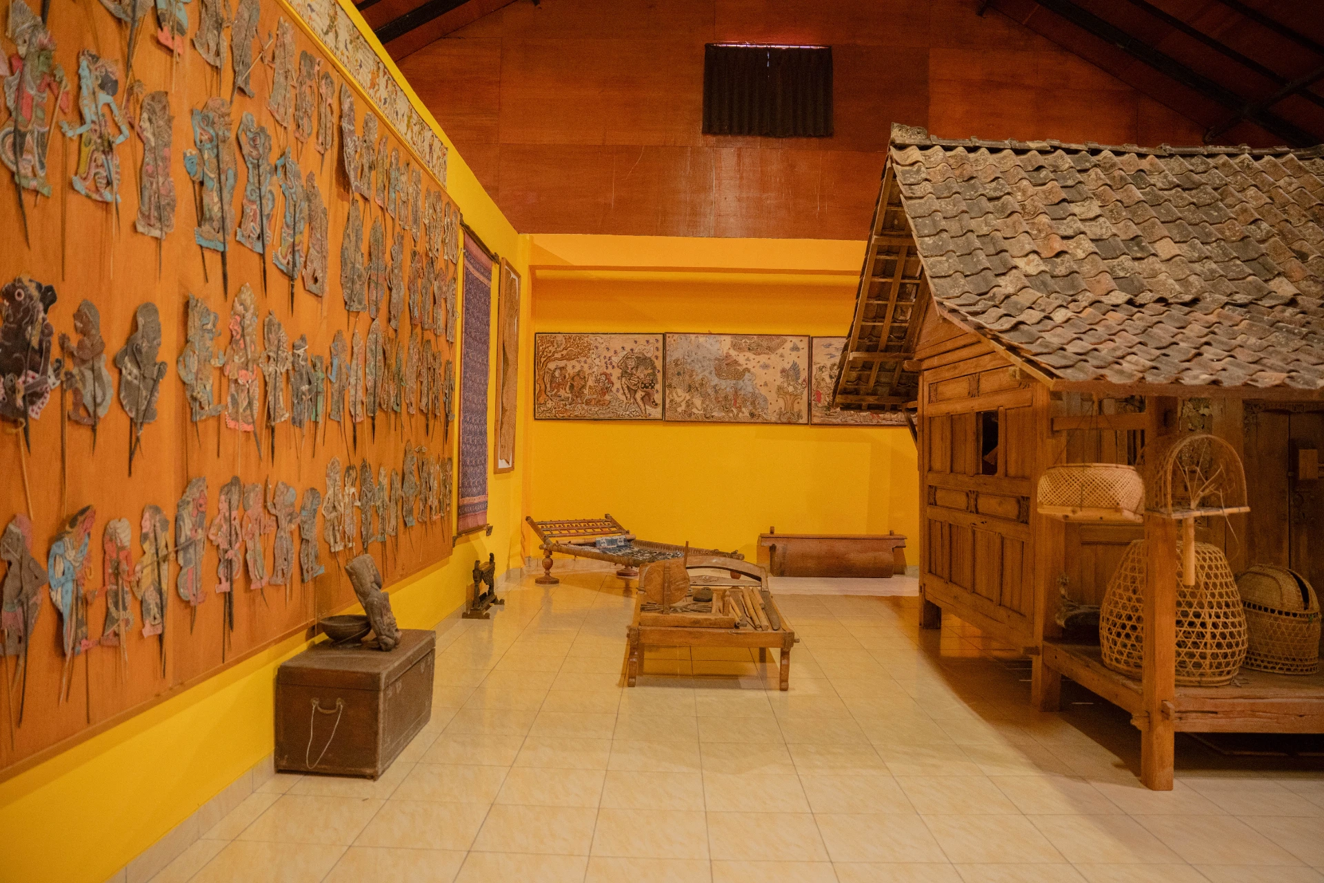 Architectural display of a traditional wooden house from Tuban with historical Balinese ornaments and artifacts.
