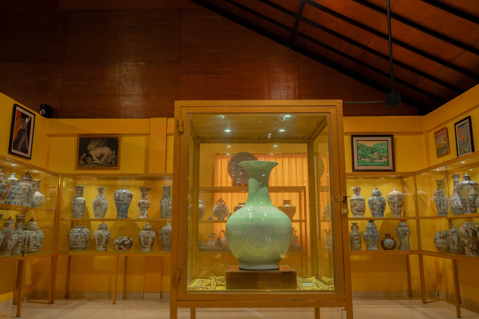Curated large glass display of ancient Chinese dynasty porcelain jars and vessels, Museum Peter Bloch Collection.