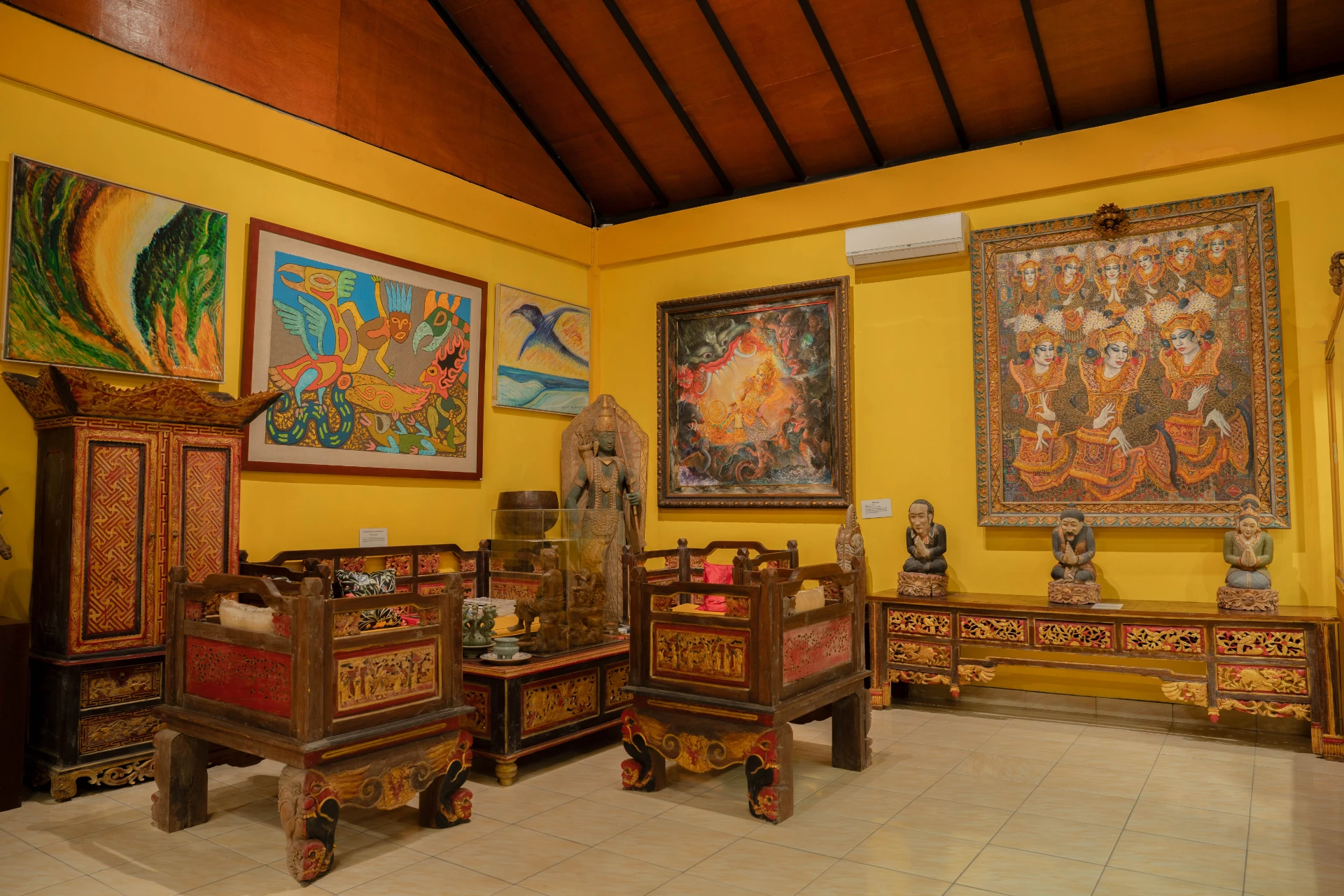 19th-century colonial-style furniture and artifact display cases in the Mads Lange Sitting Room, Museum Peter Bloch Collection.