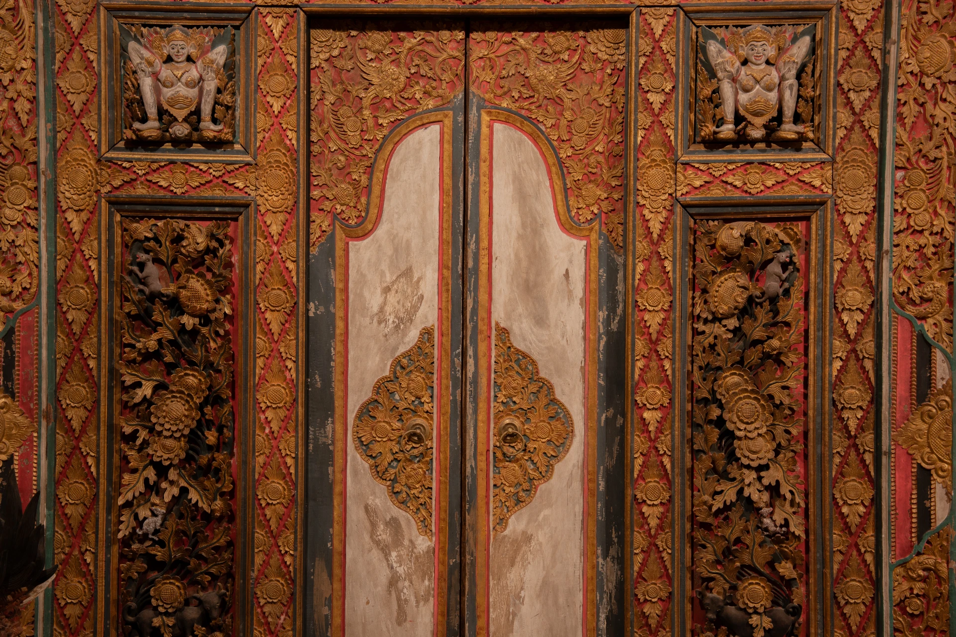 Detailed Balinese wood carvings on a traditional Bale Gede structure, Museum Peter Bloch Collection.