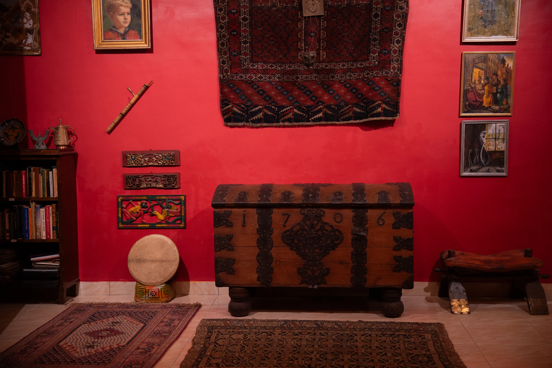 Full view of an antique Balinese-style four-poster bed in a red-walled colonial room, Museum Peter Bloch.